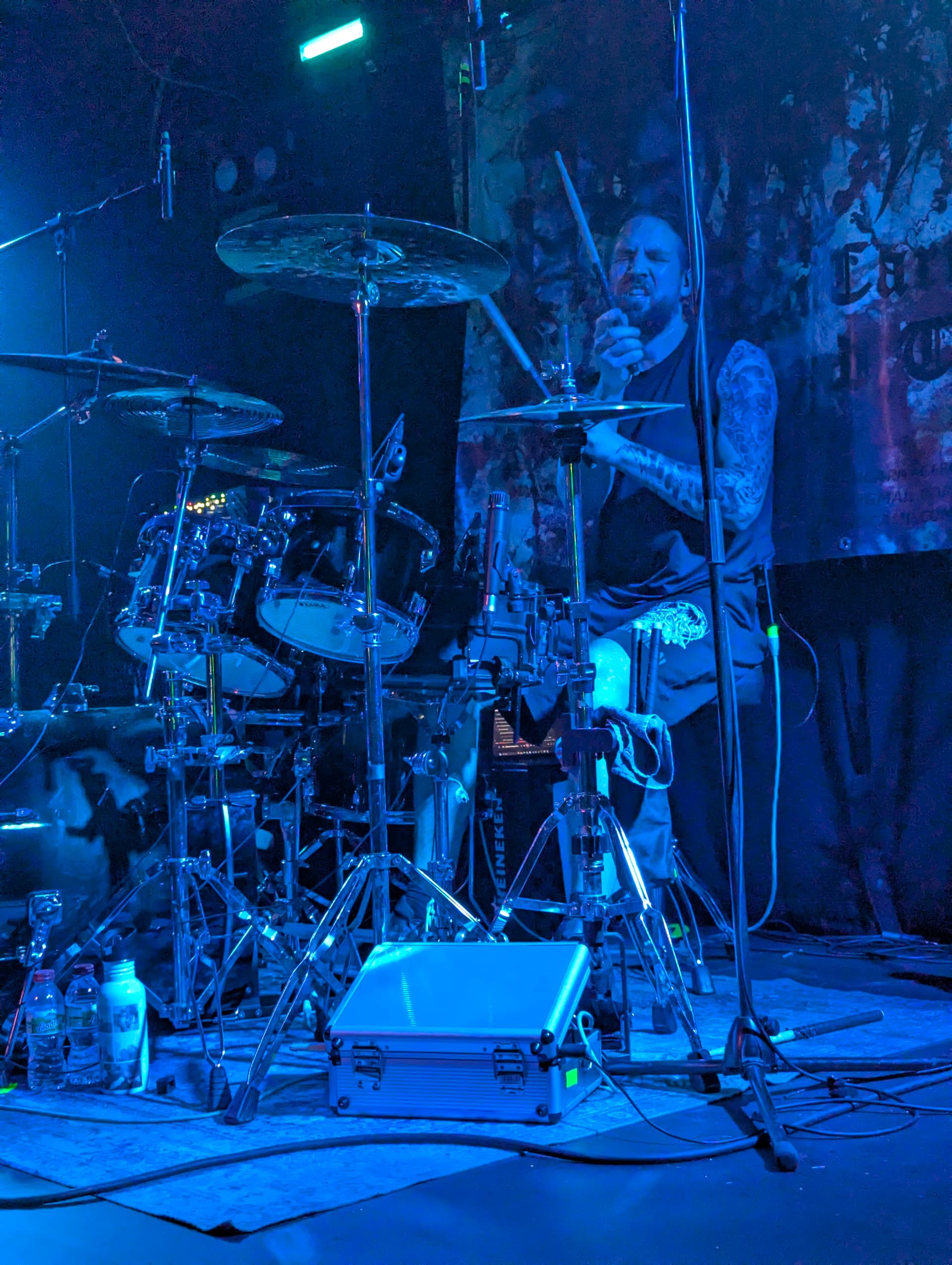 Playing drums live on a blue-lit underground stage
